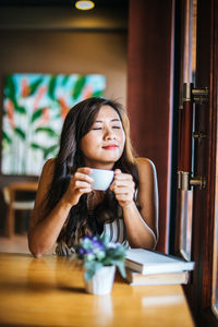 Portrait of young woman sitting in restaurant
