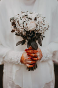 Midsection of woman holding rose bouquet