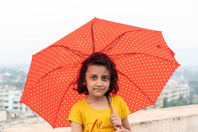 Portrait of a girl standing with umbrella