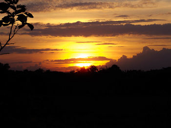 Scenic view of silhouette landscape against orange sky