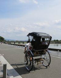 Rear view of man riding pedicab on road