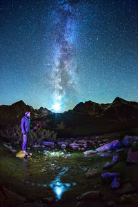 Man standing on mountain against sky at night
