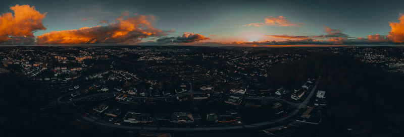 High angle view of illuminated buildings in city at sunset