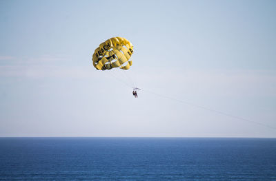 People parasailing over sea against sky