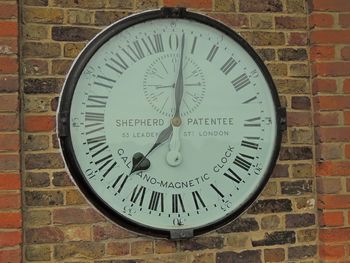 Close-up of information sign on brick wall