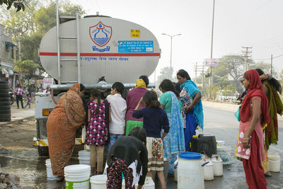 Rear view of people standing on street