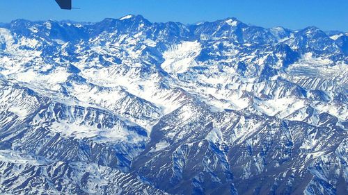 Full frame shot of snow covered mountains against blue sky