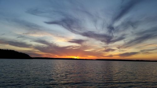 Scenic view of sea against dramatic sky during sunset