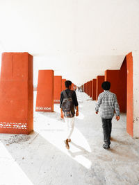 Rear view of men walking on wall