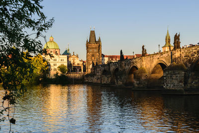 Arch bridge over river against buildings