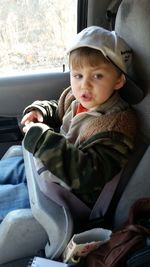 Cute boy sitting in car