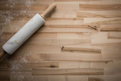 High angle view of table, flour and marble rolling pin 