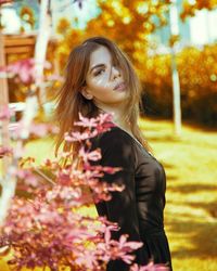 Portrait of woman standing against plants during autumn