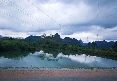 Scenic view of lake by mountains against sky