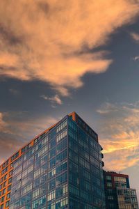 Low angle view of modern building against sky during sunset