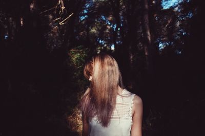 Woman standing on tree trunk