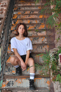 Portrait of young woman sitting on staircase