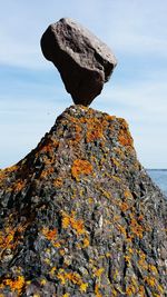 Low angle view of rocks against sky on sunny day