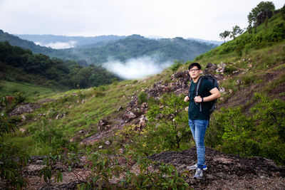 Full length of man standing on landscape against mountains