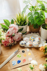 Flat lay of modern easter eggs painted. brushes and paints with flowers and plants. happy easter