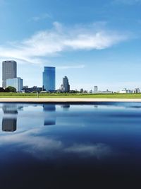 Reflection of buildings in city against sky