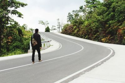 Rear view of man on road against sky