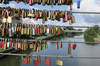 Close-up of padlocks hanging on railing against sky