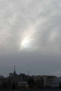 Sunlight streaming through buildings in city against sky