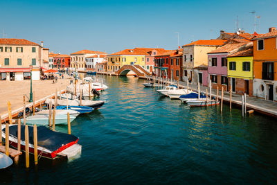 Typical murano canal with colorful houses and moored boats