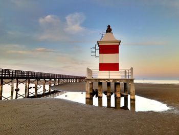 Lighthouse by sea against sky