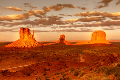 Rock formations on landscape against sky during sunset