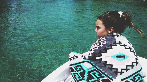 Rear high angle view of teenage girl wearing towel while traveling on boat at torch river