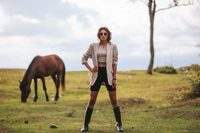 Side view of young woman standing on field