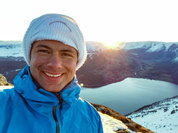 Portrait of smiling man on snowcapped mountain 