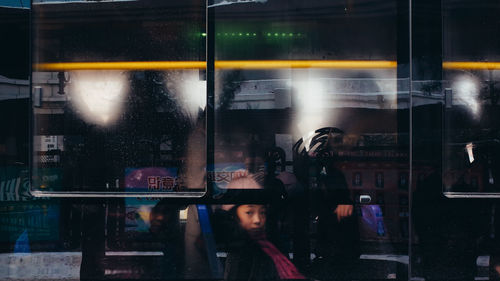 Reflection of man on glass window at night