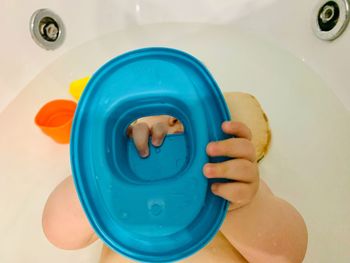 Directly above shot of person holding camera in bathroom
