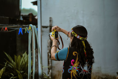 Rear view of woman with arms outstretched standing outdoors