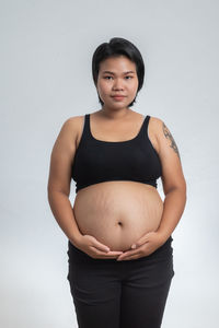 Portrait of a young woman against white background