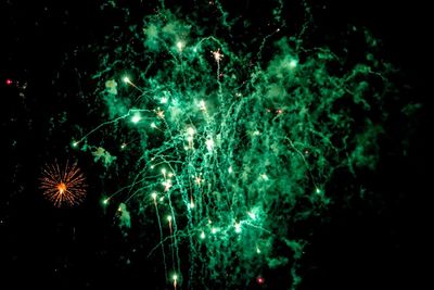 Low angle view of firework display at night