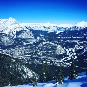 Scenic view of snowcapped mountains against blue sky