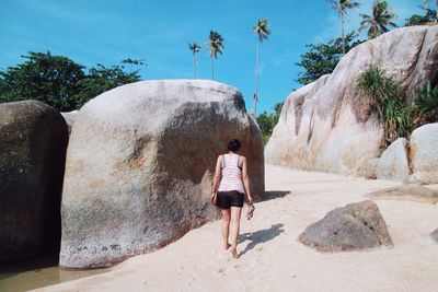 Rear view of woman walking on rock