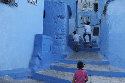 Rear view of people on staircase against building