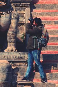 Full length of man photographing at camera