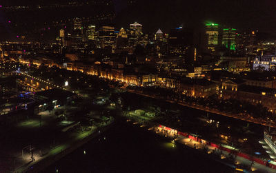 High angle view of illuminated buildings by river at night