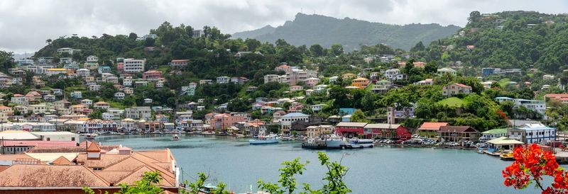 Panoramic view of townscape by river against sky