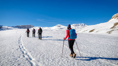 Rear view of woman walking on snow covered mountain