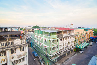 High angle view of buildings by street against sky