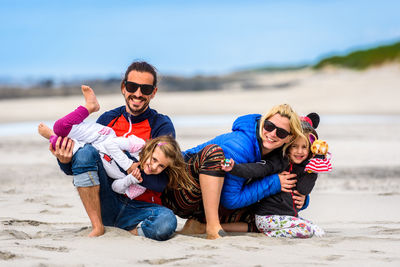 Full length portrait of happy friends enjoying at beach