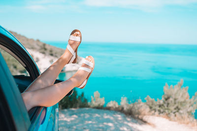 Woman hand on sea shore against sky