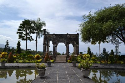 Gazebo in park against cloudy sky